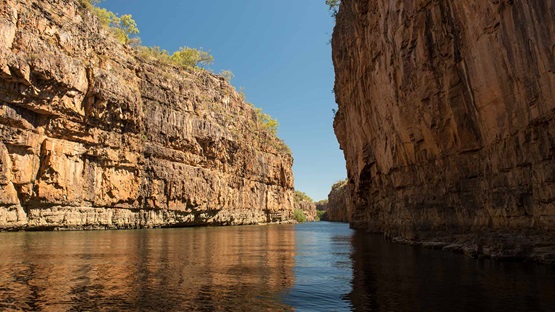 Towering sandstone cliffs reflecting in the river below