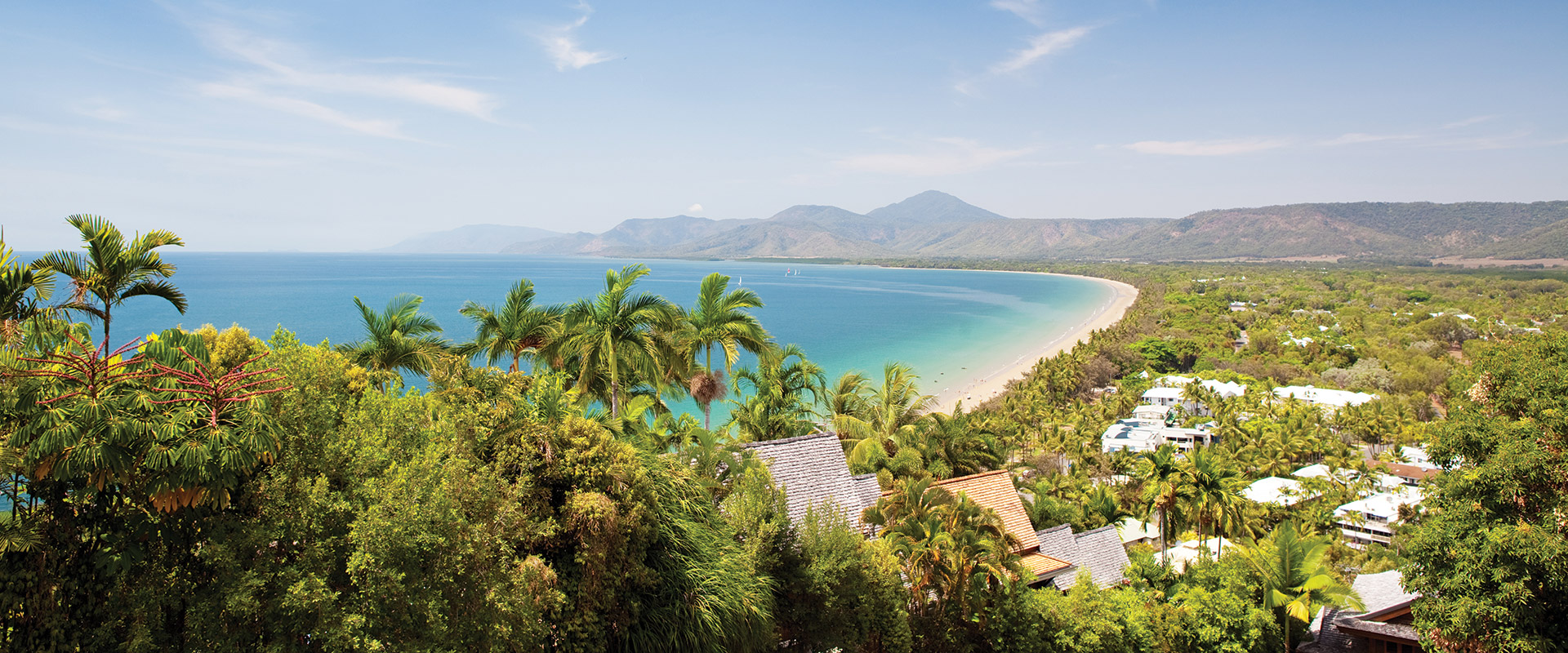 Aerial view over the coastal town of Port Douglas set amongst the palm trees and turquoise waters