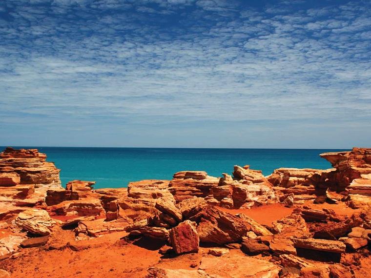 View of red rocks in foreground of sea at Gantheaume Point, Broome