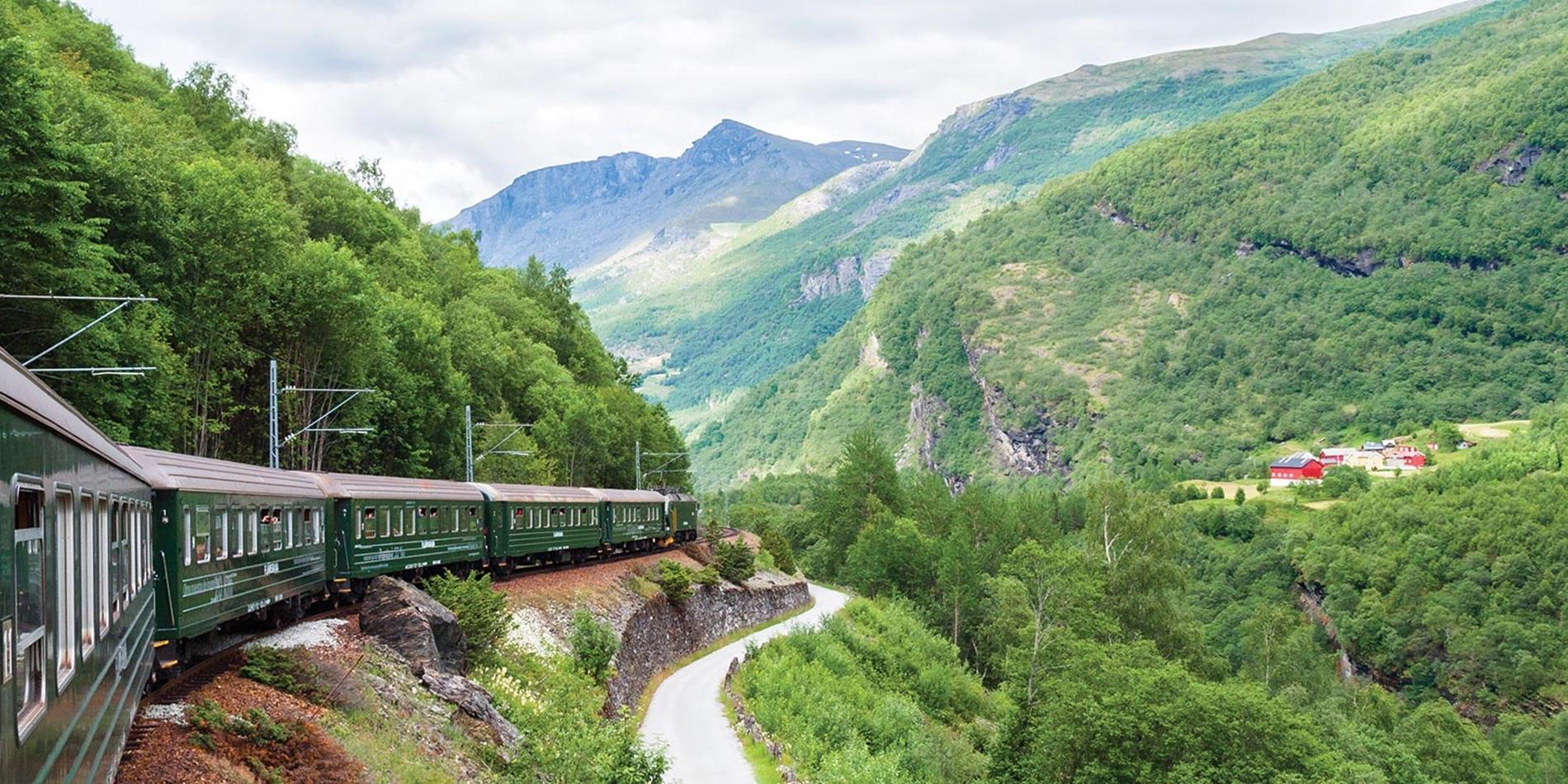 View of train traveling alongside a mountain, Norway