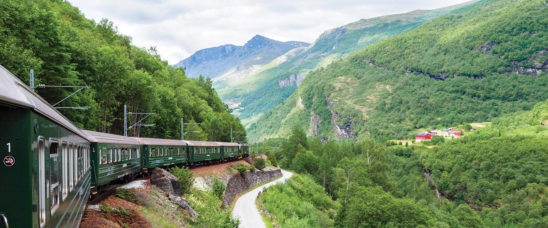 View of train traveling alongside a mountain, Norway