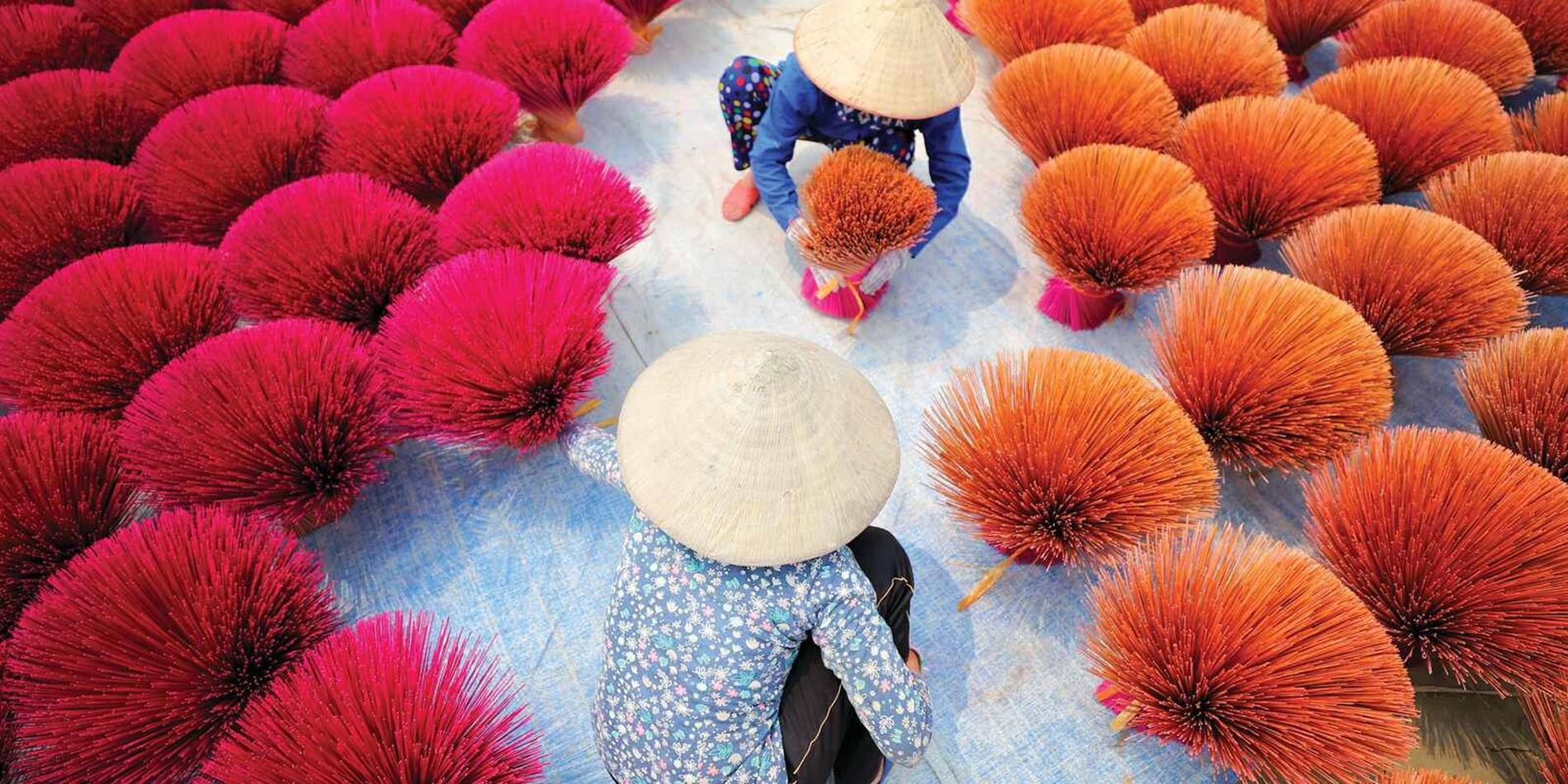 Vietnamese ladies working with colourful insence sticks