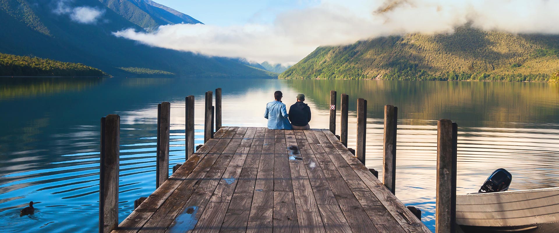 Couple sitting on a jetty at Nelson Lakes National Park