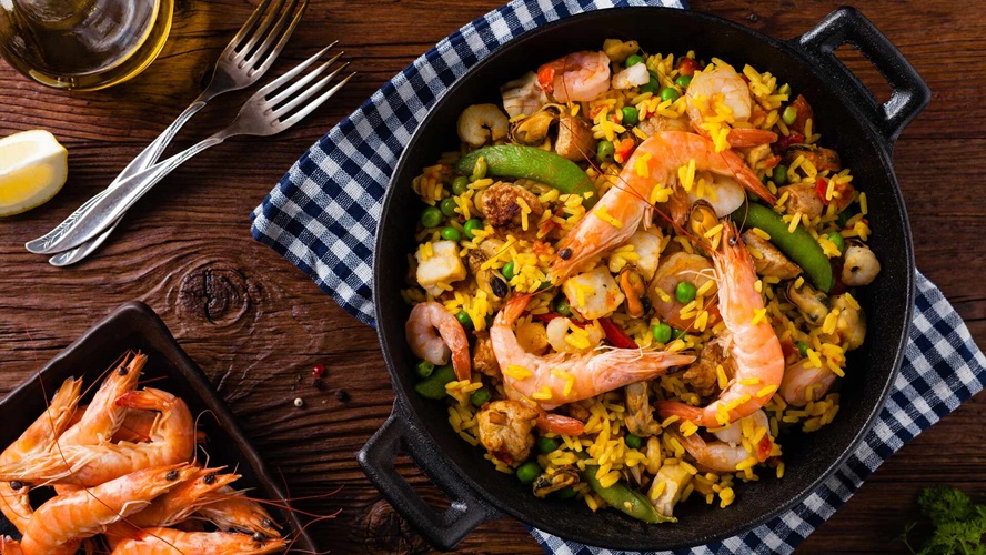 Traditional Spanish paella with seafood and chicken. Prepared in wok. Top view.