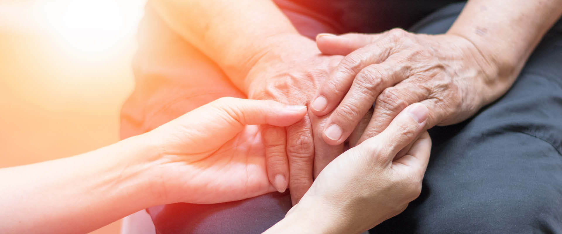 Caregiver holding hands of elder