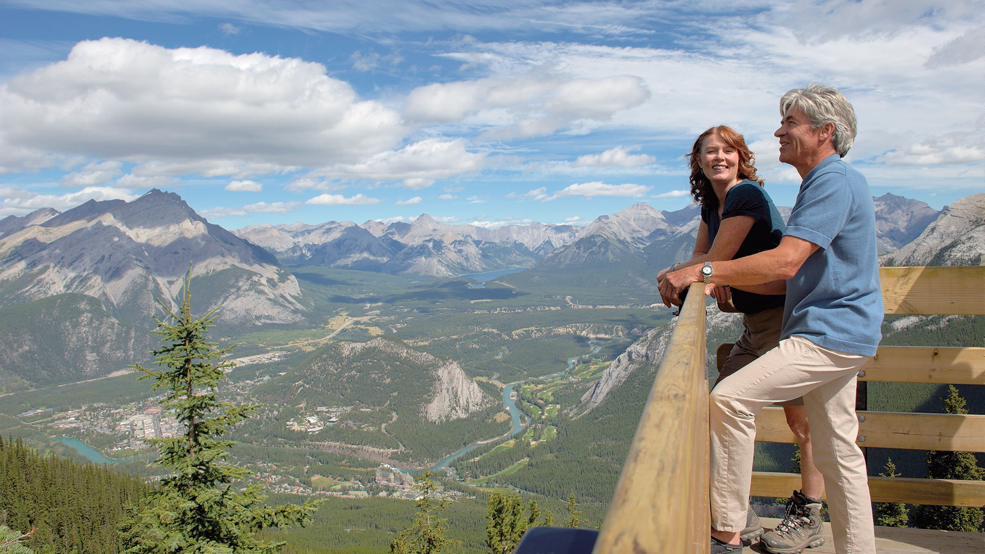 Two people enjoying the Banff view from a Brewster Gondola viewing platform.