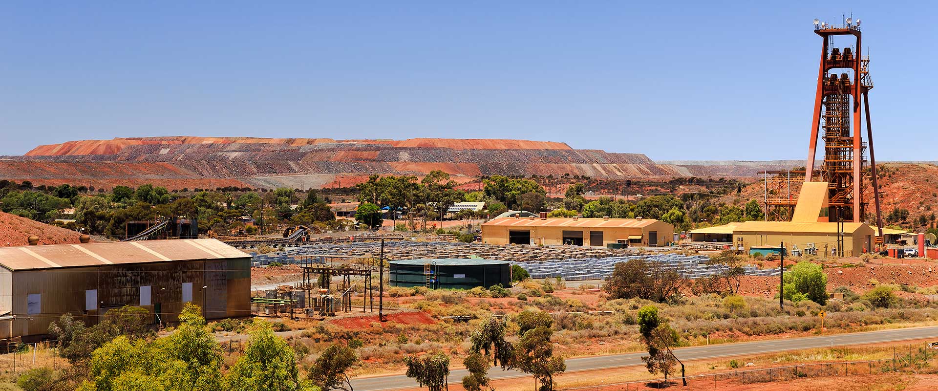 Pit frame of an old gold mine surrounded by red outback dirt and low brush shrubs in Kalgoorlie