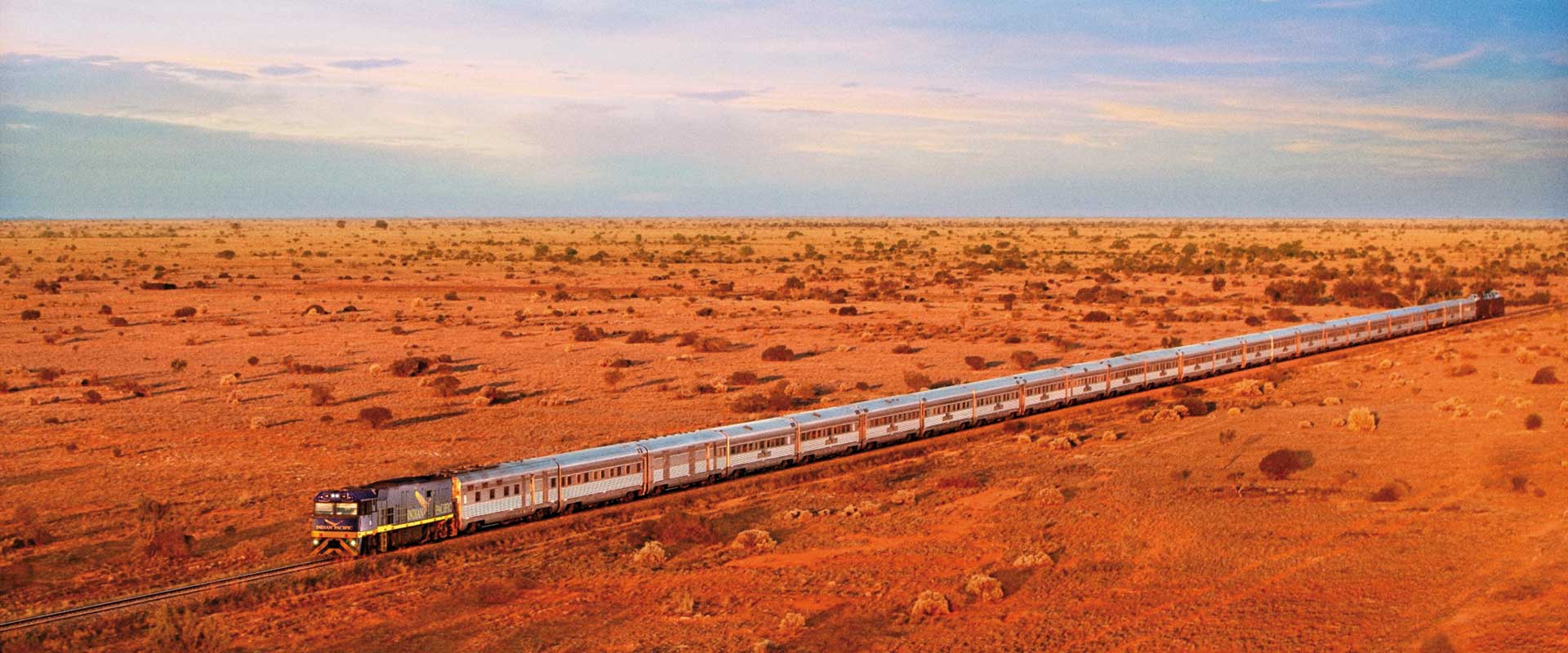 Indian Pacific train travelling through a red desert